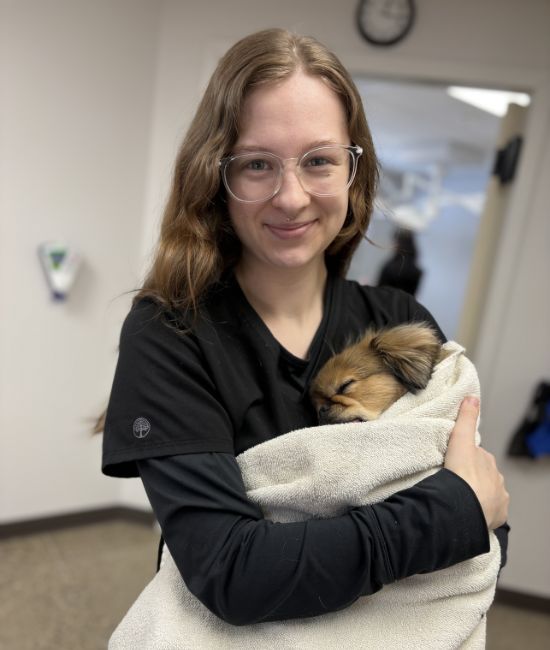 Mallory affectionately holding a dog after surgery